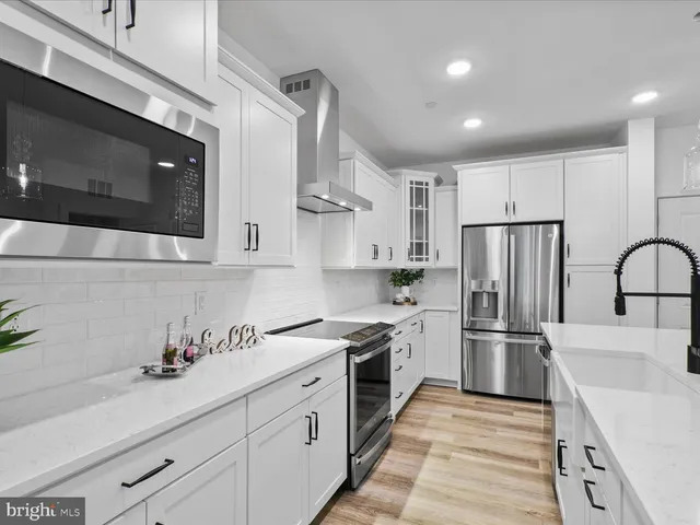 a kitchen with stainless steel appliances granite countertop a refrigerator sink and stove