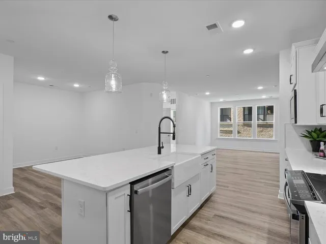 a kitchen with a sink and wooden floor