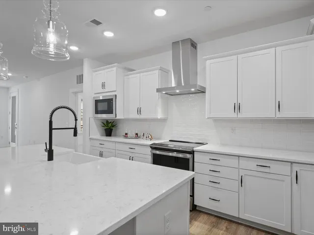 a kitchen with white cabinets and appliances