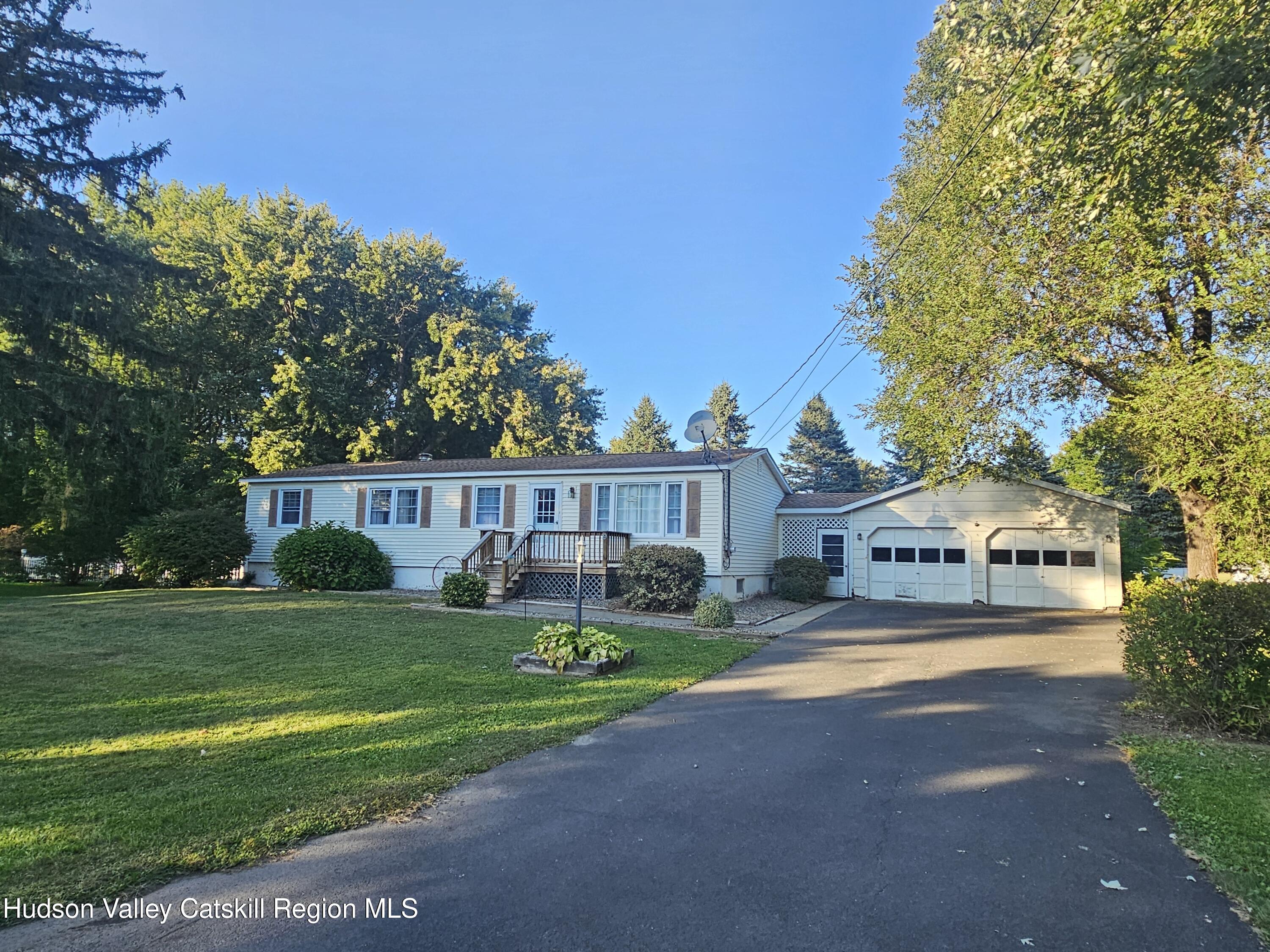 a view of house with garden and tall trees