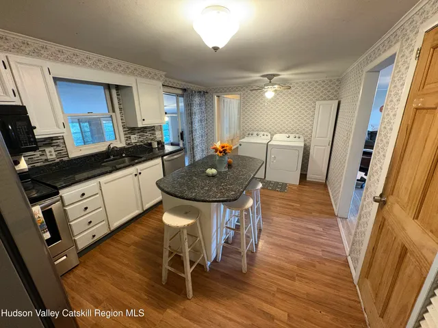 a kitchen with granite countertop a table chairs sink and wooden floor
