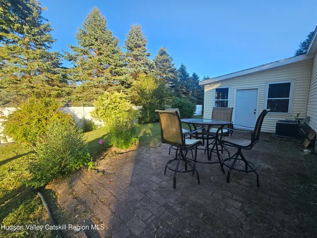 a view of a backyard with furniture and a yard
