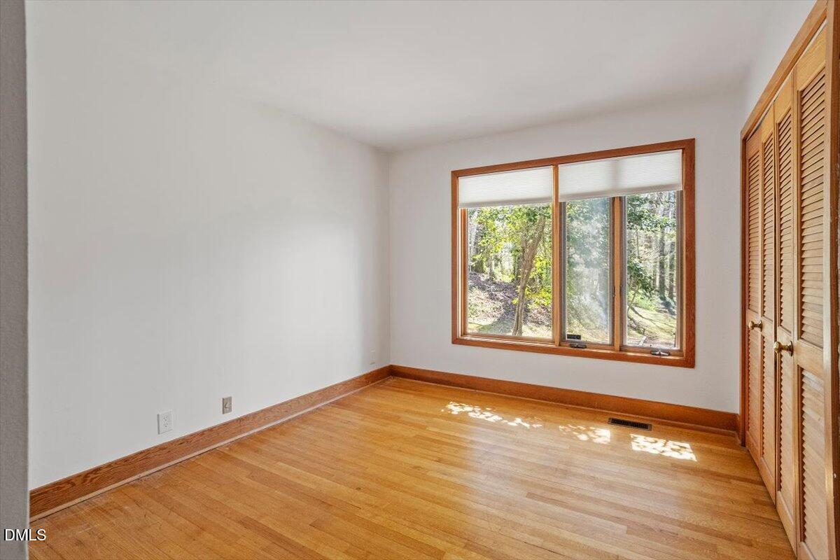 4805 Rembert Drive Raleigh, NC 27612 - Photo 20 of 45 a view of an empty room with wooden floor and a window