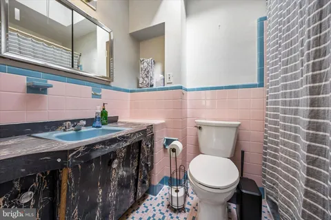 a bathroom with a granite countertop toilet and a sink