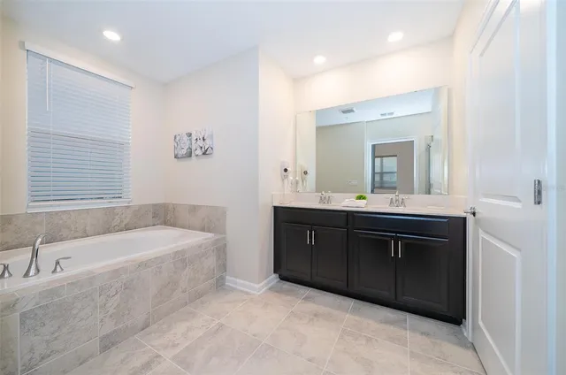 a bathroom with a tub sink and mirror