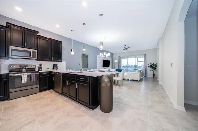 a kitchen with stainless steel appliances kitchen island granite countertop a stove refrigerator and cabinets