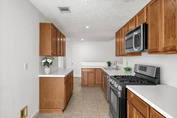 a kitchen with stainless steel appliances granite countertop a sink stove and microwave