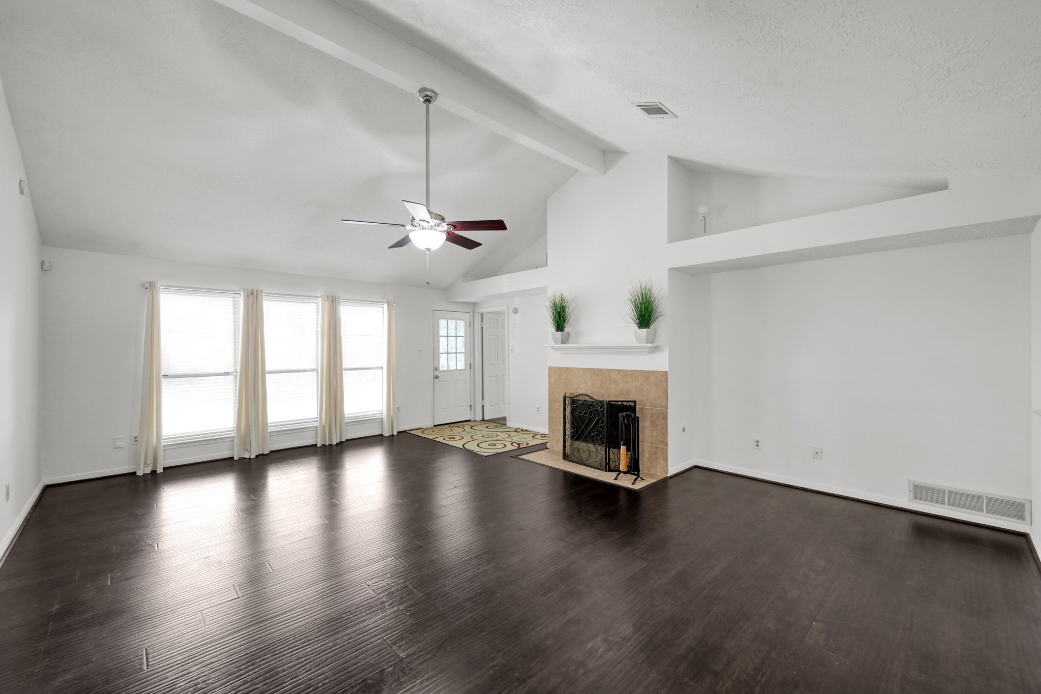 3406 Hartfield Lane Spring, TX 77388 - Photo 16 of 44 an empty room with wooden floor fireplace and windows