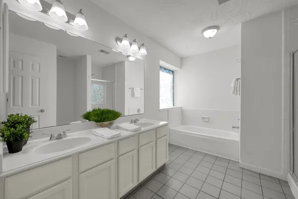 a bathroom with a sink a large mirror and a bathtub