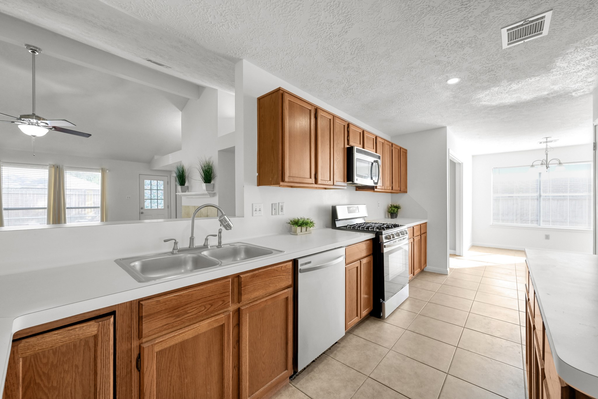 3406 Hartfield Lane Spring, TX 77388 - Photo 10 of 44 a large kitchen with stainless steel appliances granite countertop a sink and cabinets