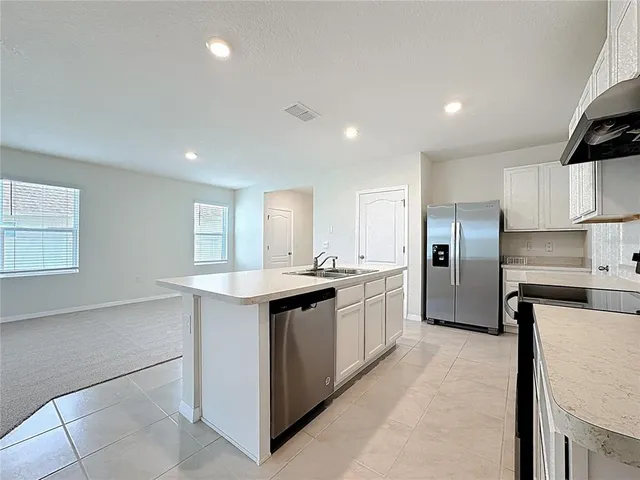 a kitchen with stainless steel appliances granite countertop a sink and a refrigerator