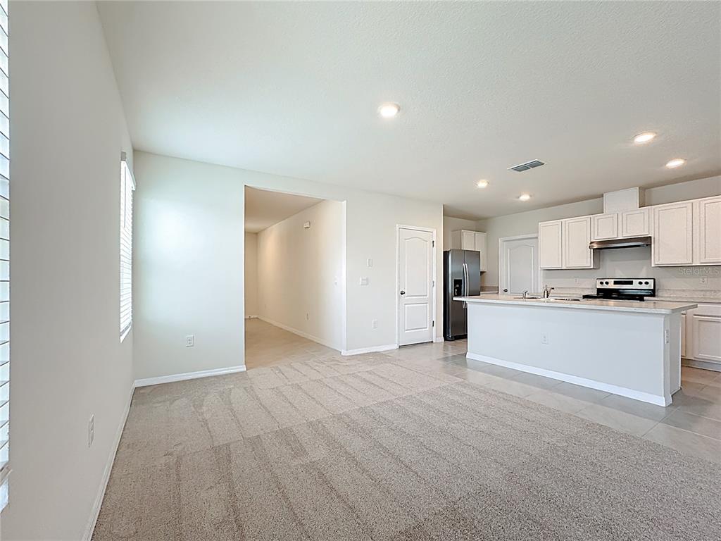 2692 Reddish Egret Bend, Unit 1 St. Cloud, FL 34773 - Photo 14 of 30 a view of a kitchen with a sink and dishwasher a refrigerator with white cabinets