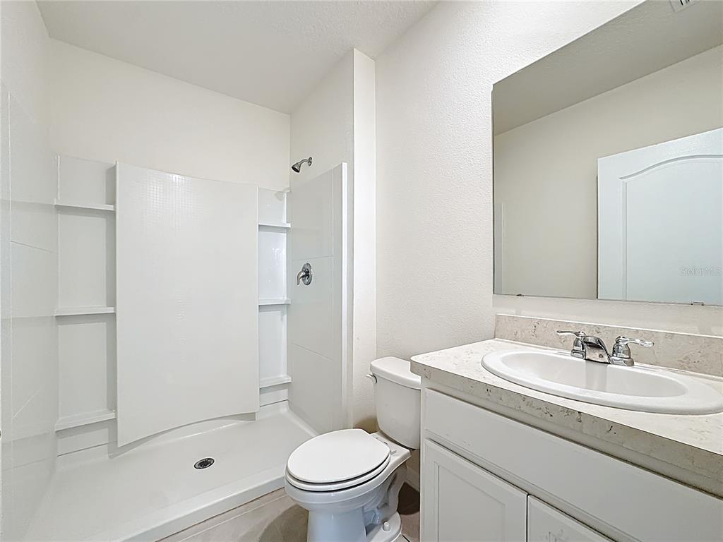 2692 Reddish Egret Bend, Unit 1 St. Cloud, FL 34773 - Photo 24 of 30 a bathroom with a sink toilet and shower