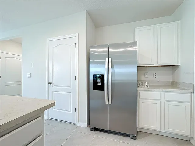 a kitchen with cabinets and a refrigerator