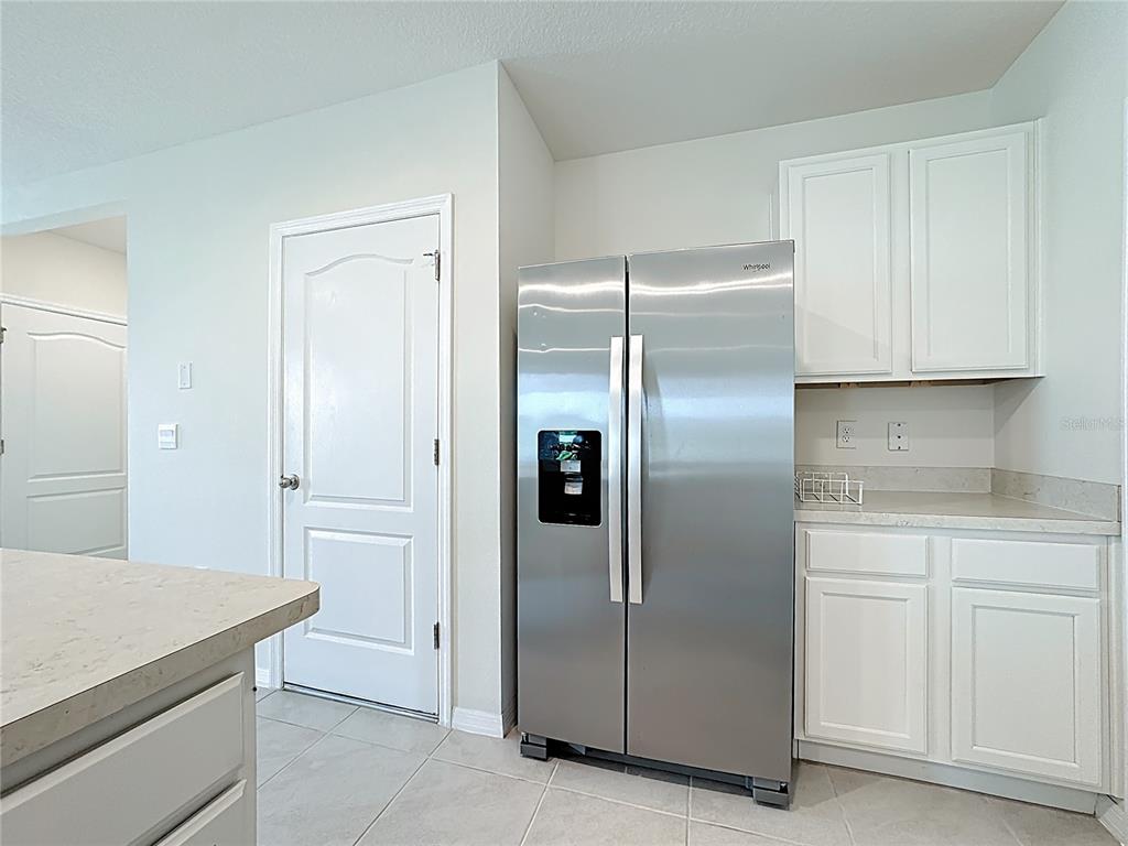2692 Reddish Egret Bend, Unit 1 St. Cloud, FL 34773 - Photo 10 of 30 a kitchen with cabinets and a refrigerator