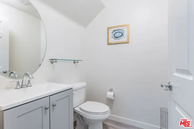 a bathroom with a toilet sink vanity and mirror