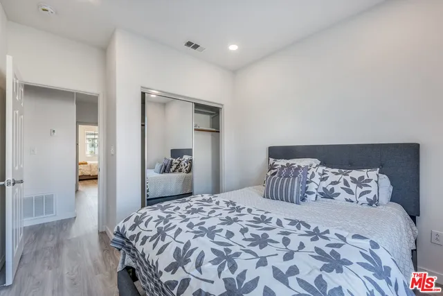 a bedroom with a bed and wooden floor