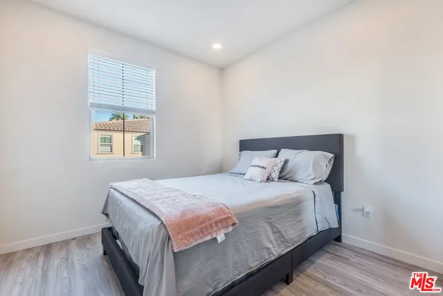 a bedroom with a bed and wooden floor