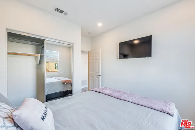 a bedroom with a bed and a flat screen tv