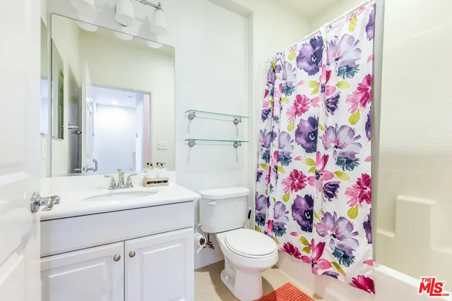 a bathroom with a sink mirror vanity and toilet