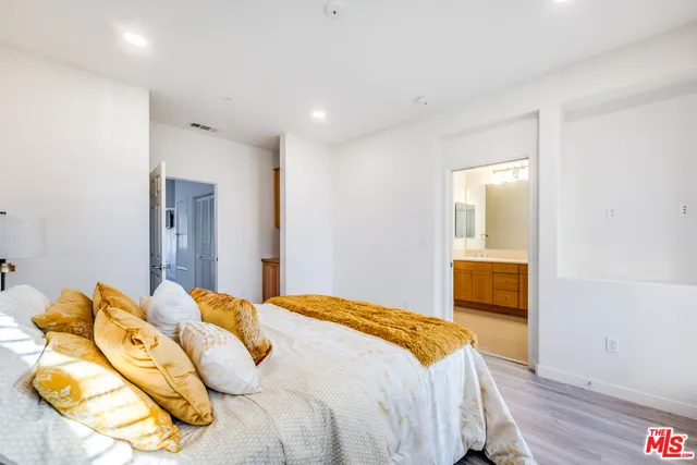 a bedroom with a bed and wooden floor