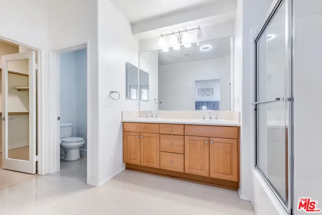 a spacious bathroom with a granite countertop sink toilet a large mirror a shower and a bathtub