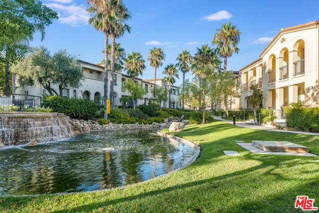 a view of a house with a yard and potted plants