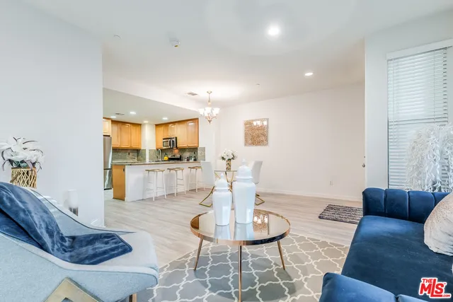 a living room with furniture and a dining table with kitchen view