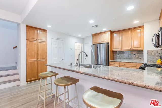 a large kitchen with granite countertop a sink and a refrigerator
