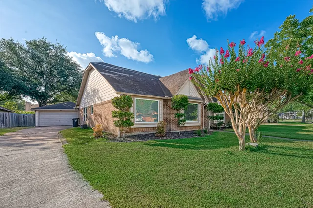 a view of a house with a yard and a garden
