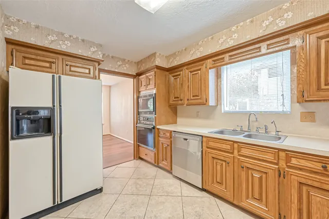 a kitchen with stainless steel appliances granite countertop a refrigerator and a sink