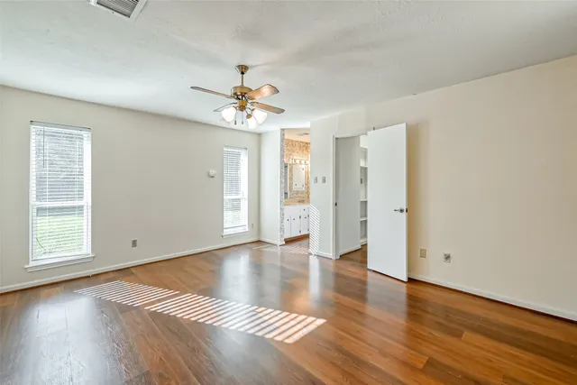an empty room with wooden floor and window