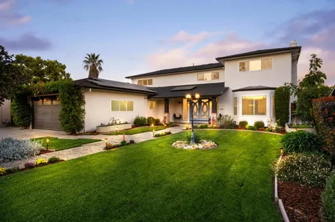 a view of a house with backyard and a tree