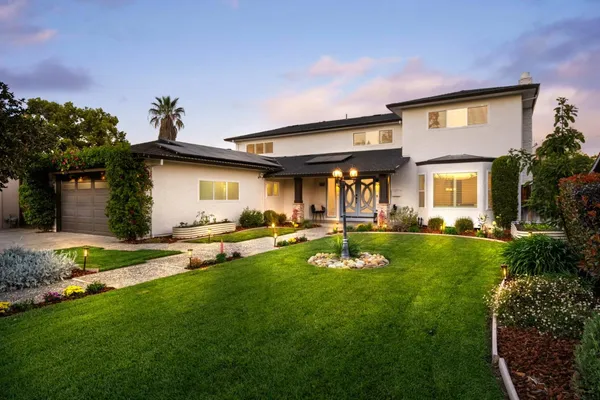 a view of a house with backyard and a tree