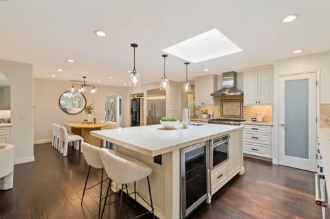 a large kitchen with stainless steel appliances a large center island and a wooden floors