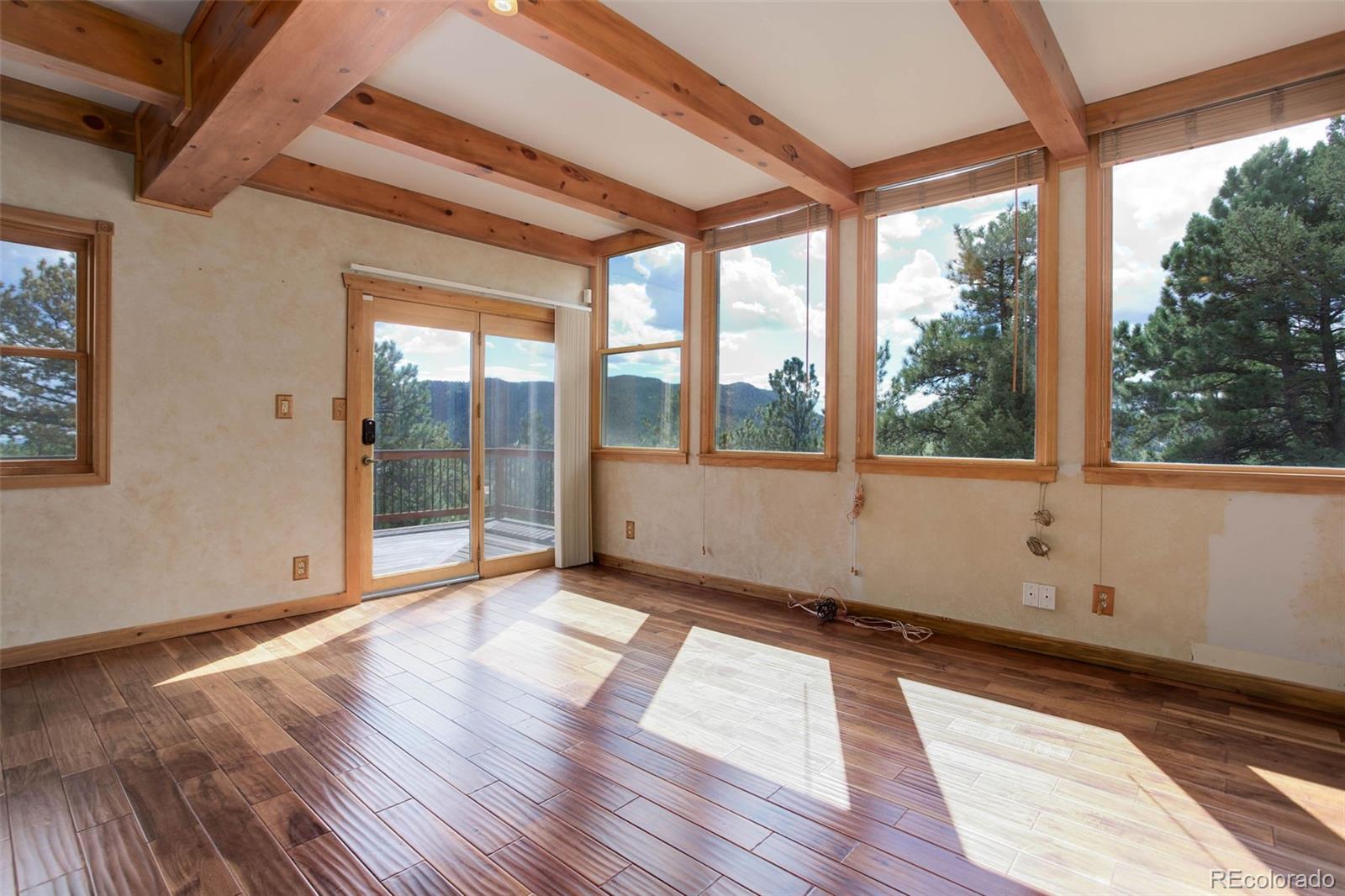 9209 Fallen Rock Road Conifer, CO 80433 - Photo 11 of 33 a view of empty room with wooden floor and fan