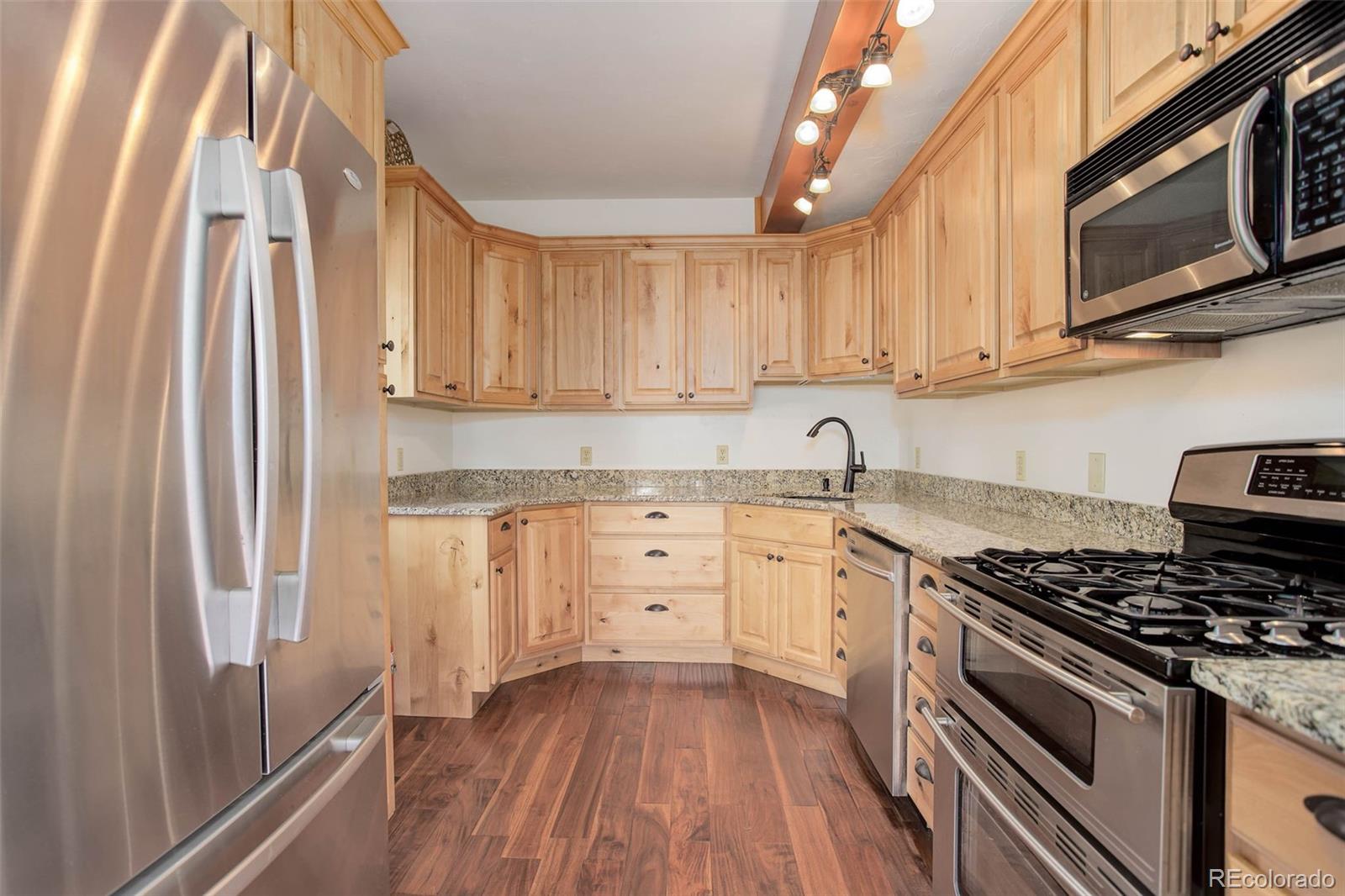 9209 Fallen Rock Road Conifer, CO 80433 - Photo 13 of 33 a kitchen with granite countertop a sink stainless steel appliances and cabinets