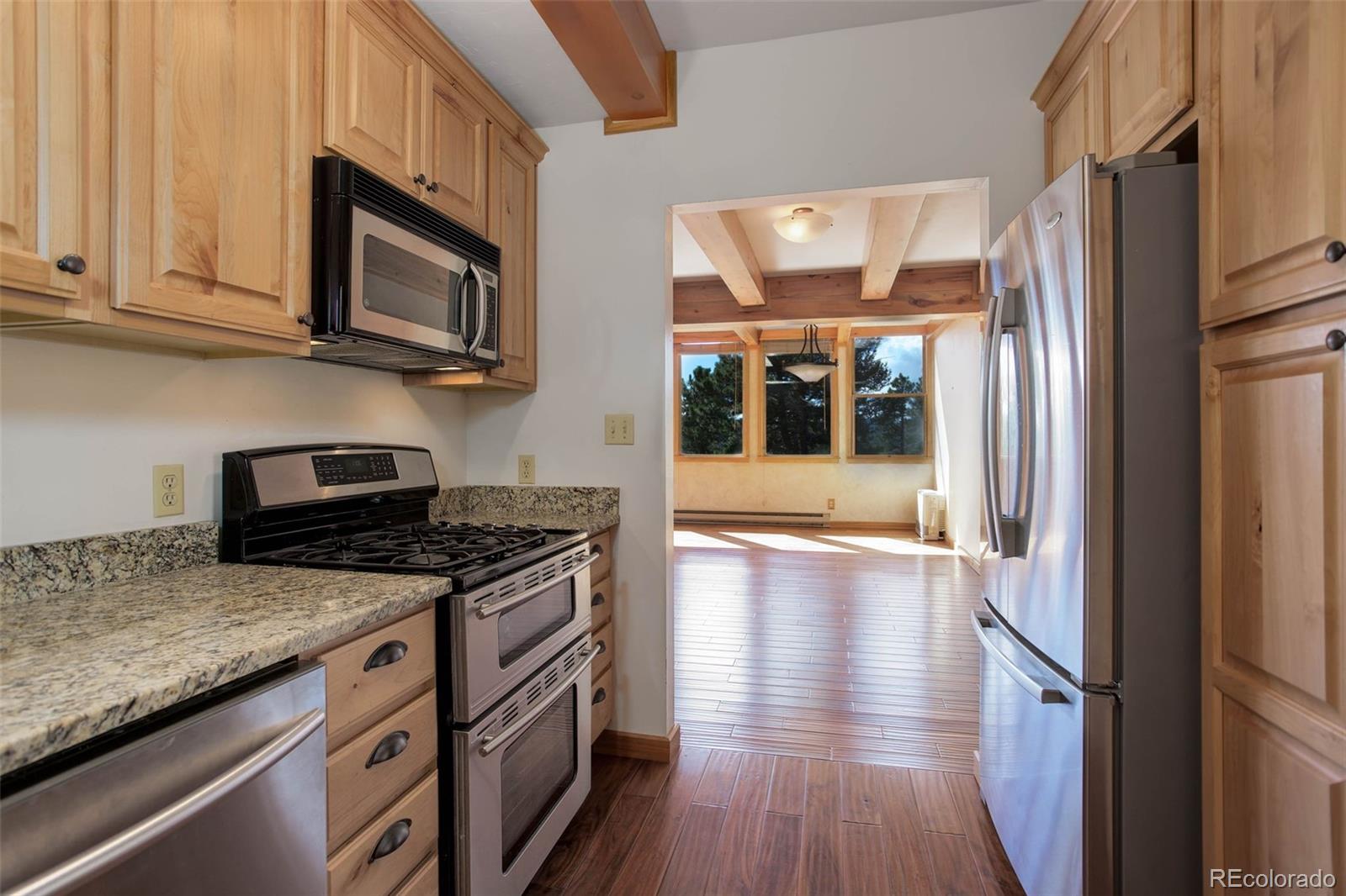 9209 Fallen Rock Road Conifer, CO 80433 - Photo 14 of 33 a kitchen with stainless steel appliances granite countertop a stove and a refrigerator