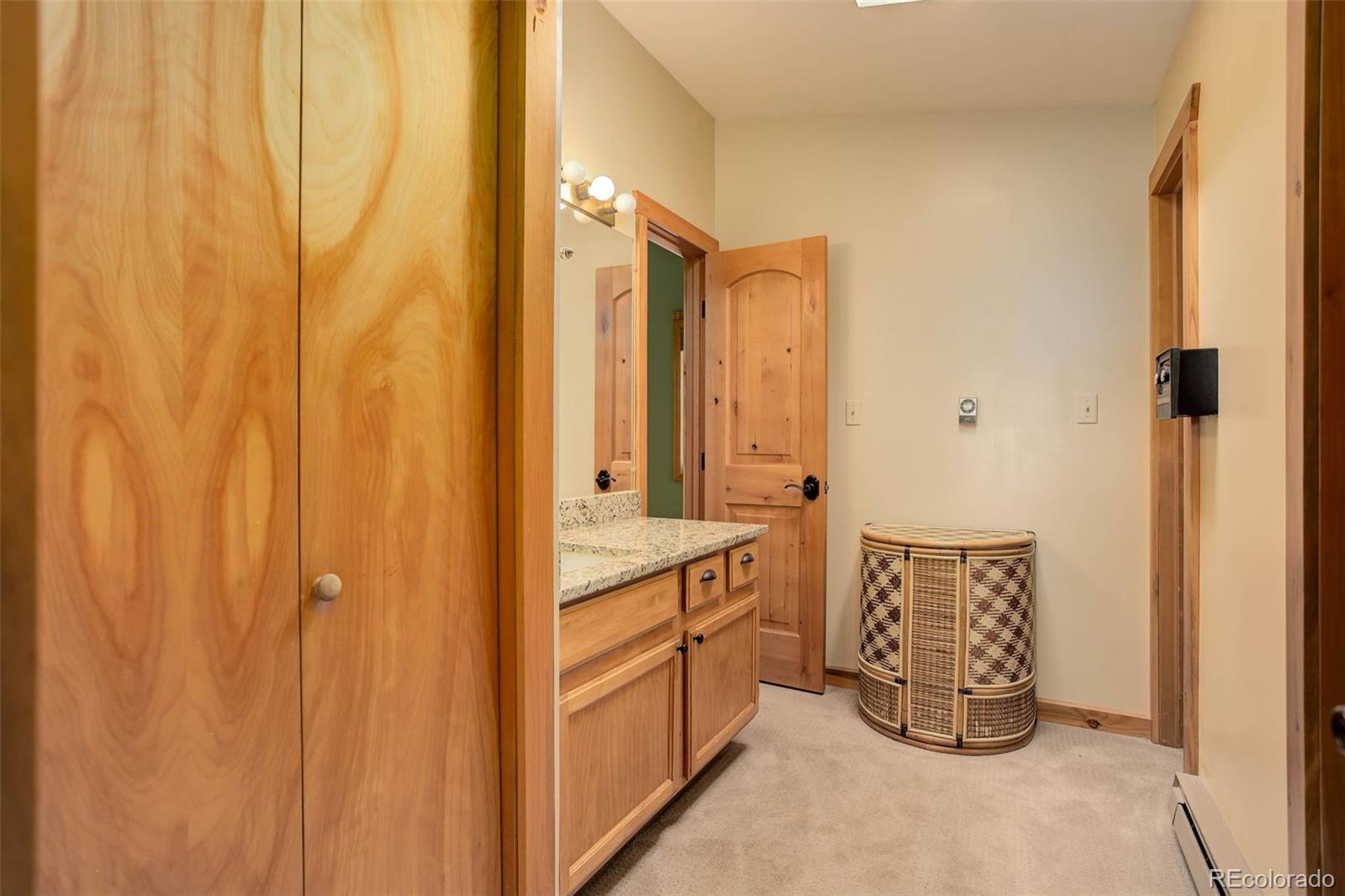 9209 Fallen Rock Road Conifer, CO 80433 - Photo 23 of 33 a bathroom with a double vanity sink and mirror