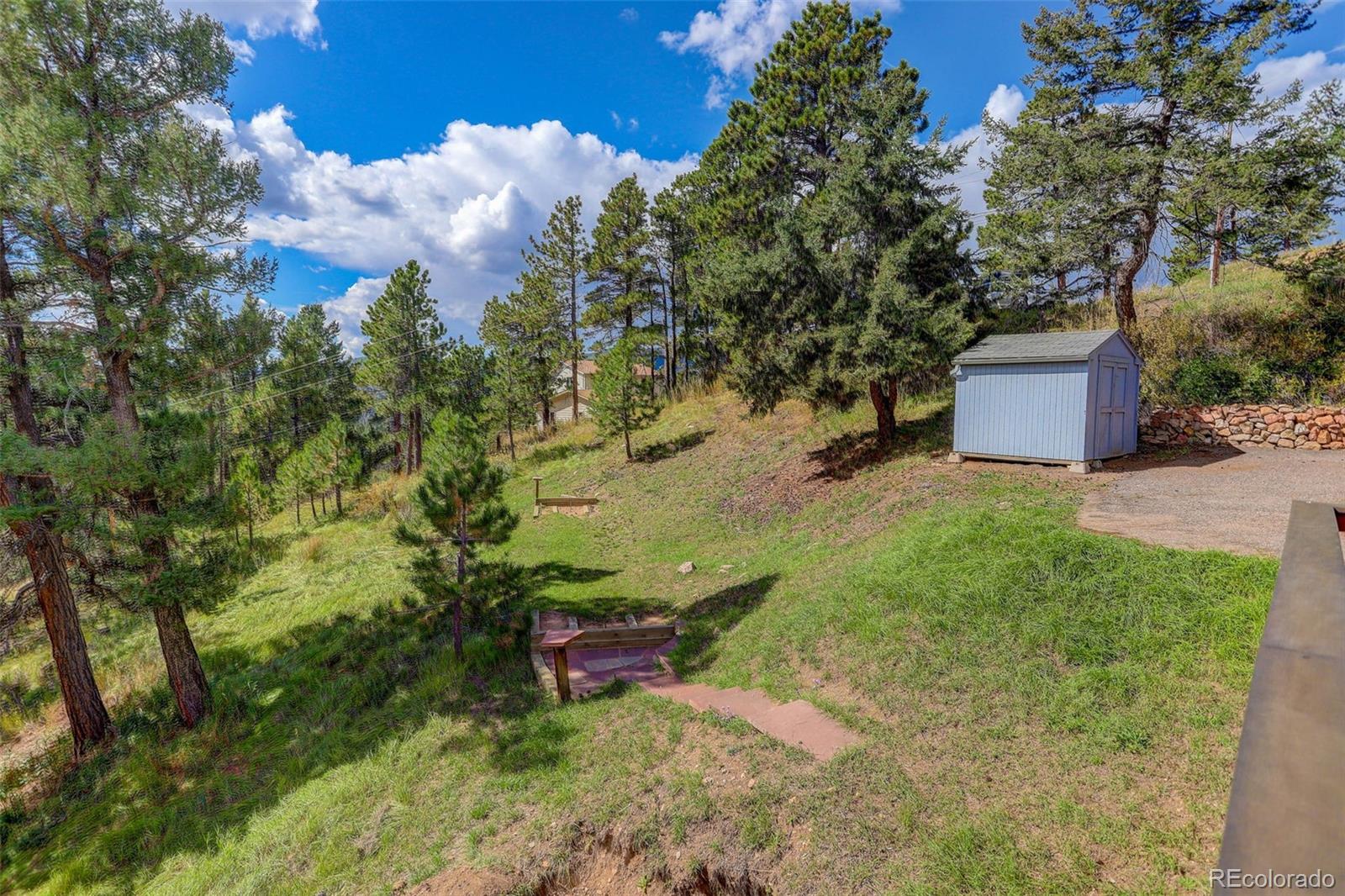9209 Fallen Rock Road Conifer, CO 80433 - Photo 31 of 33 a backyard of a house with table and chairs