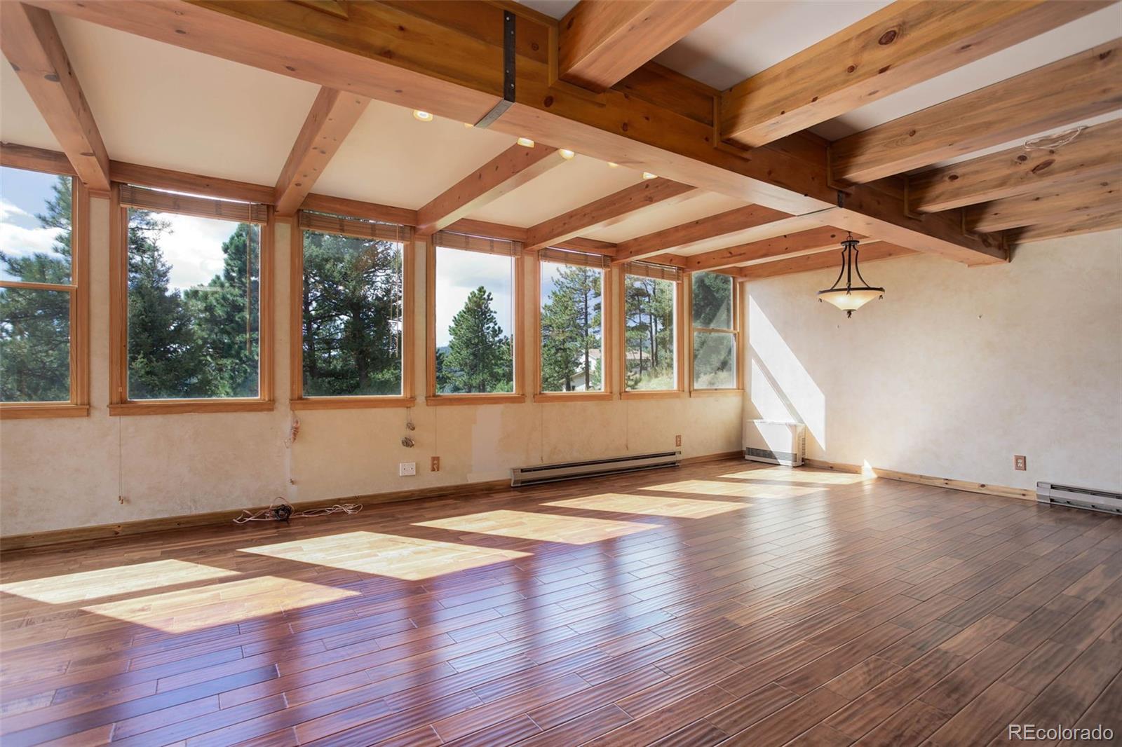 9209 Fallen Rock Road Conifer, CO 80433 - Photo 7 of 33 a view of empty room with wooden floor and fan