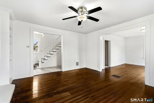 a view of an empty room with wooden floor