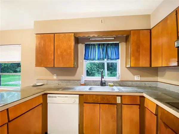 a kitchen with stainless steel appliances kitchen island granite countertop a stove a microwave and a sink