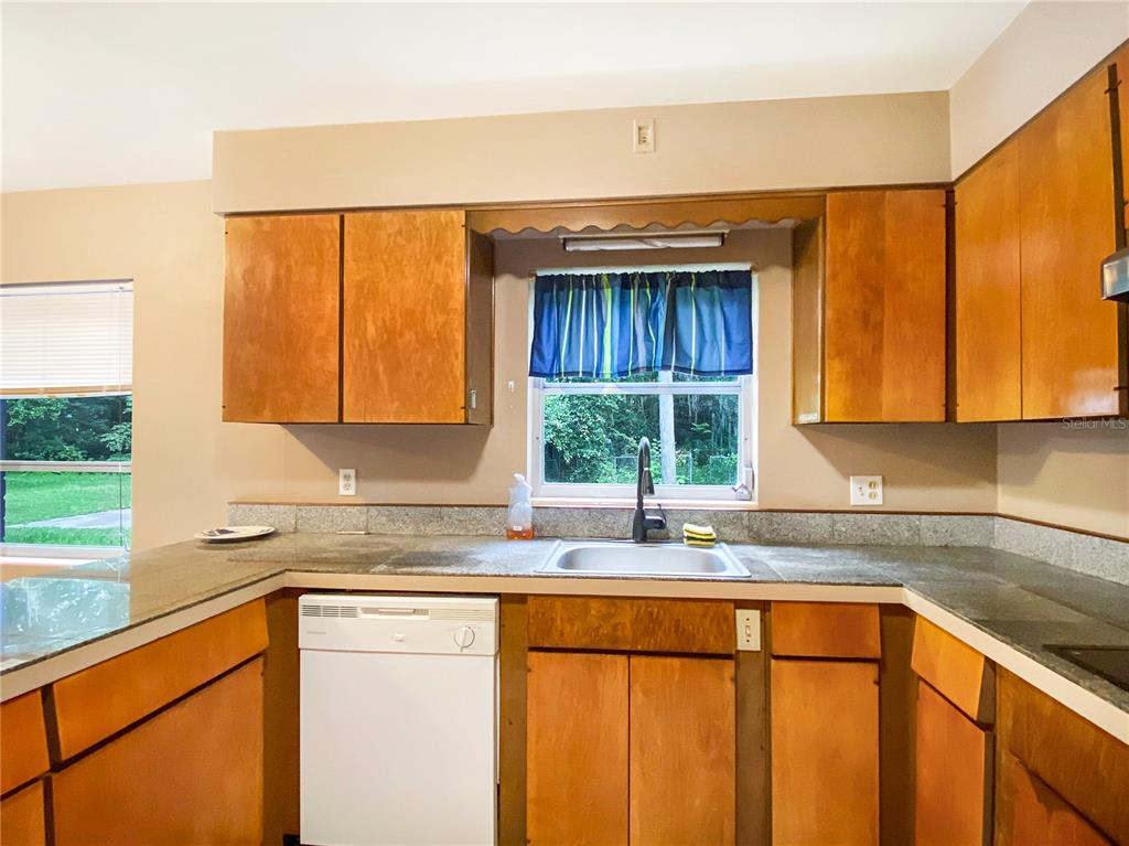 1119 Southwest 11th Avenue Gainesville, FL 32601 - Photo 11 of 30 a kitchen with stainless steel appliances granite countertop wooden cabinets a sink and a large window