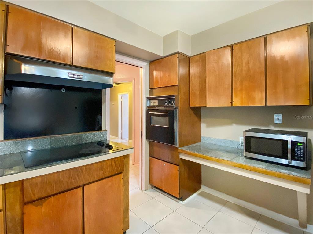 1119 Southwest 11th Avenue Gainesville, FL 32601 - Photo 12 of 30 a kitchen with stainless steel appliances kitchen island granite countertop a stove a microwave and a sink
