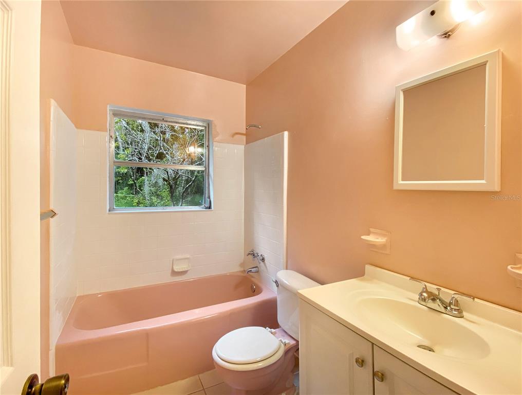 1119 Southwest 11th Avenue Gainesville, FL 32601 - Photo 15 of 30 a bathroom with a sink a toilet a mirror and a bathtub