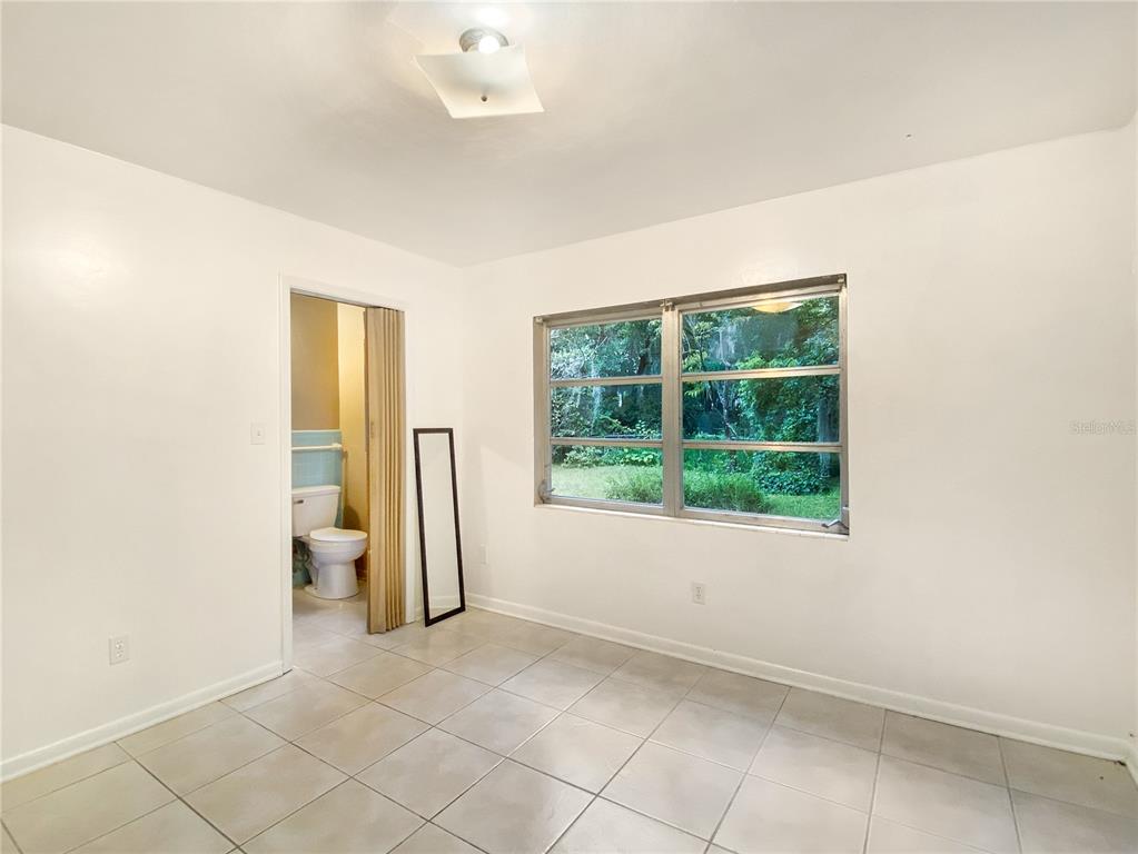 1119 Southwest 11th Avenue Gainesville, FL 32601 - Photo 21 of 30 an empty room with a fireplace and windows