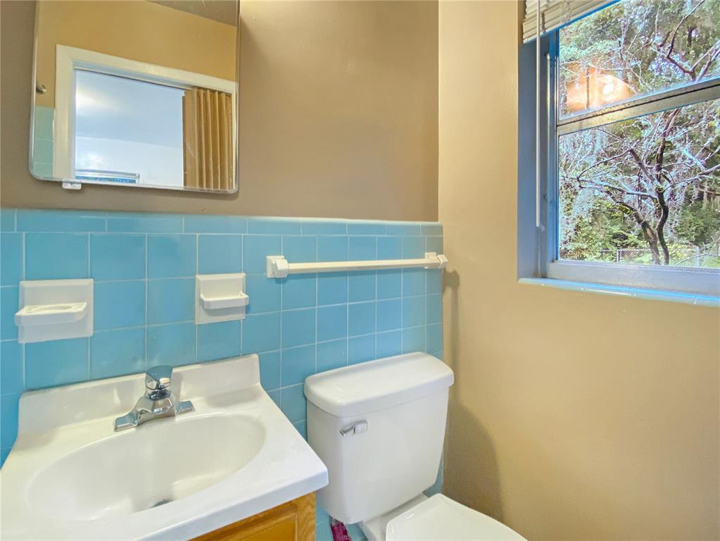 1119 Southwest 11th Avenue Gainesville, FL 32601 - Photo 23 of 30 a bathroom with a sink mirror and toilet