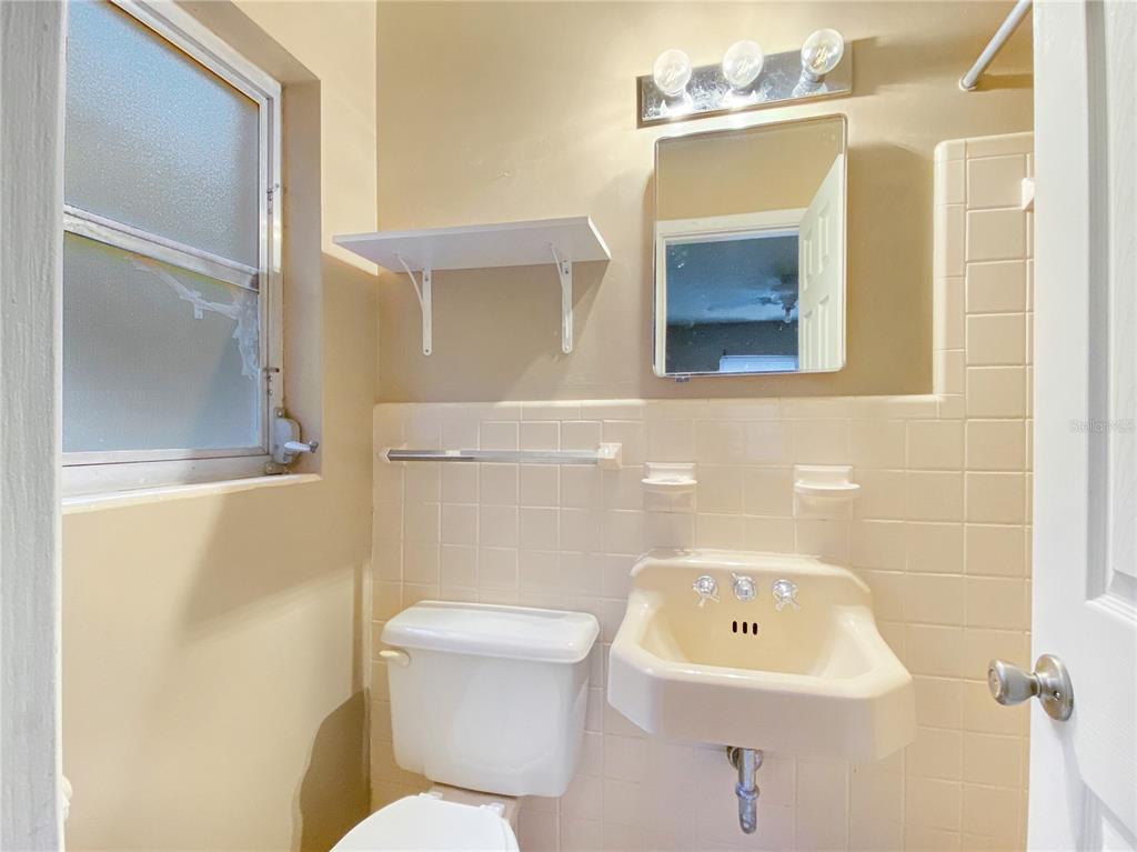 1119 Southwest 11th Avenue Gainesville, FL 32601 - Photo 25 of 30 a bathroom with a toilet sink and mirror