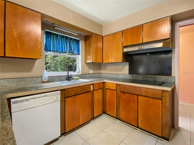 a kitchen with granite countertop a refrigerator and a sink